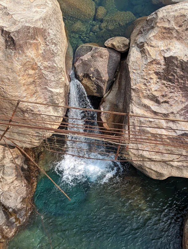 A waterfall behind a weak bridge that cannot be walked across