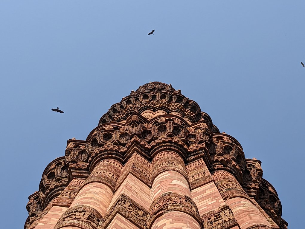 Qutub Minar - birds flying over the tower
